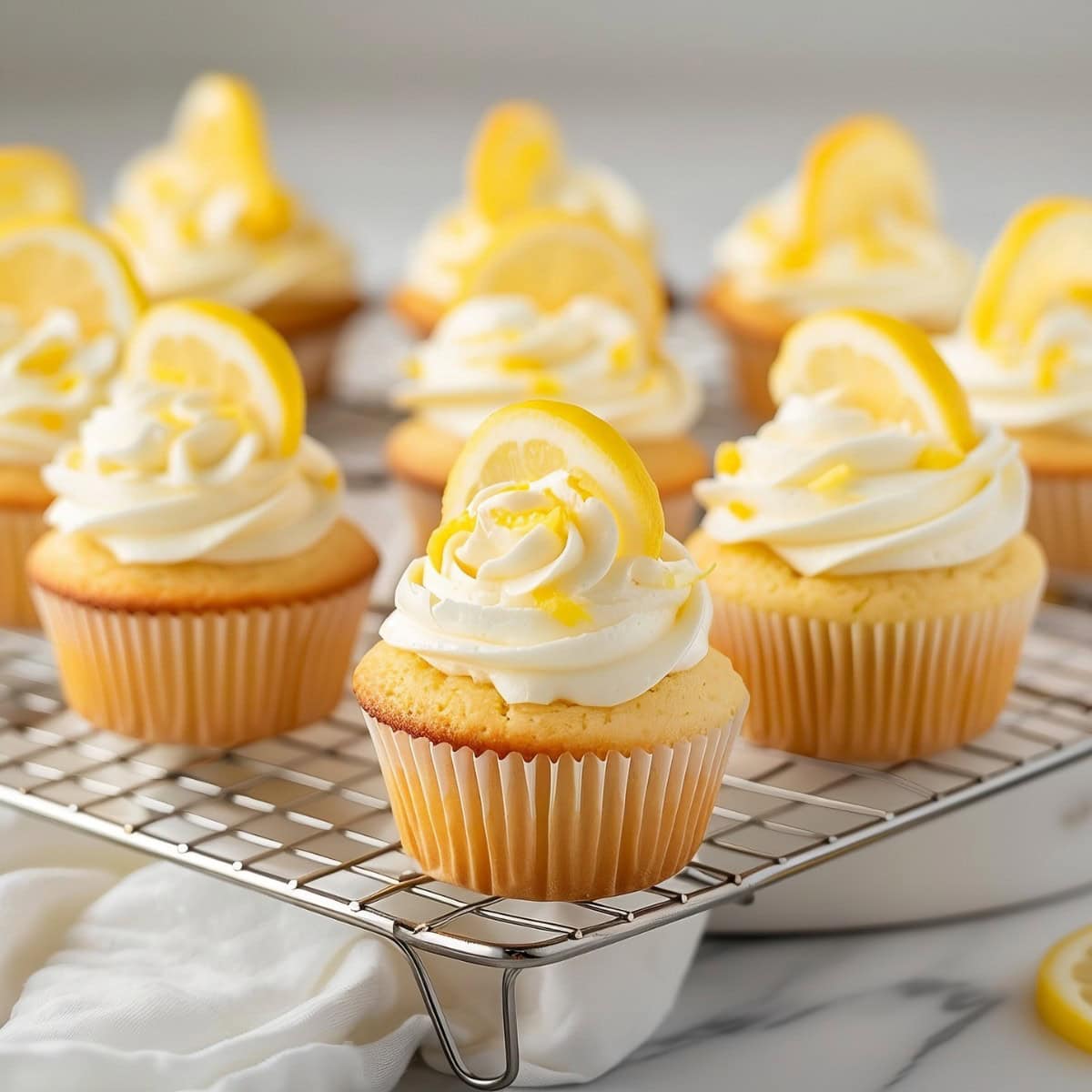 Delicious cupcakes in a cooling rack, infused with lemon zest and juice for a refreshing burst of flavor