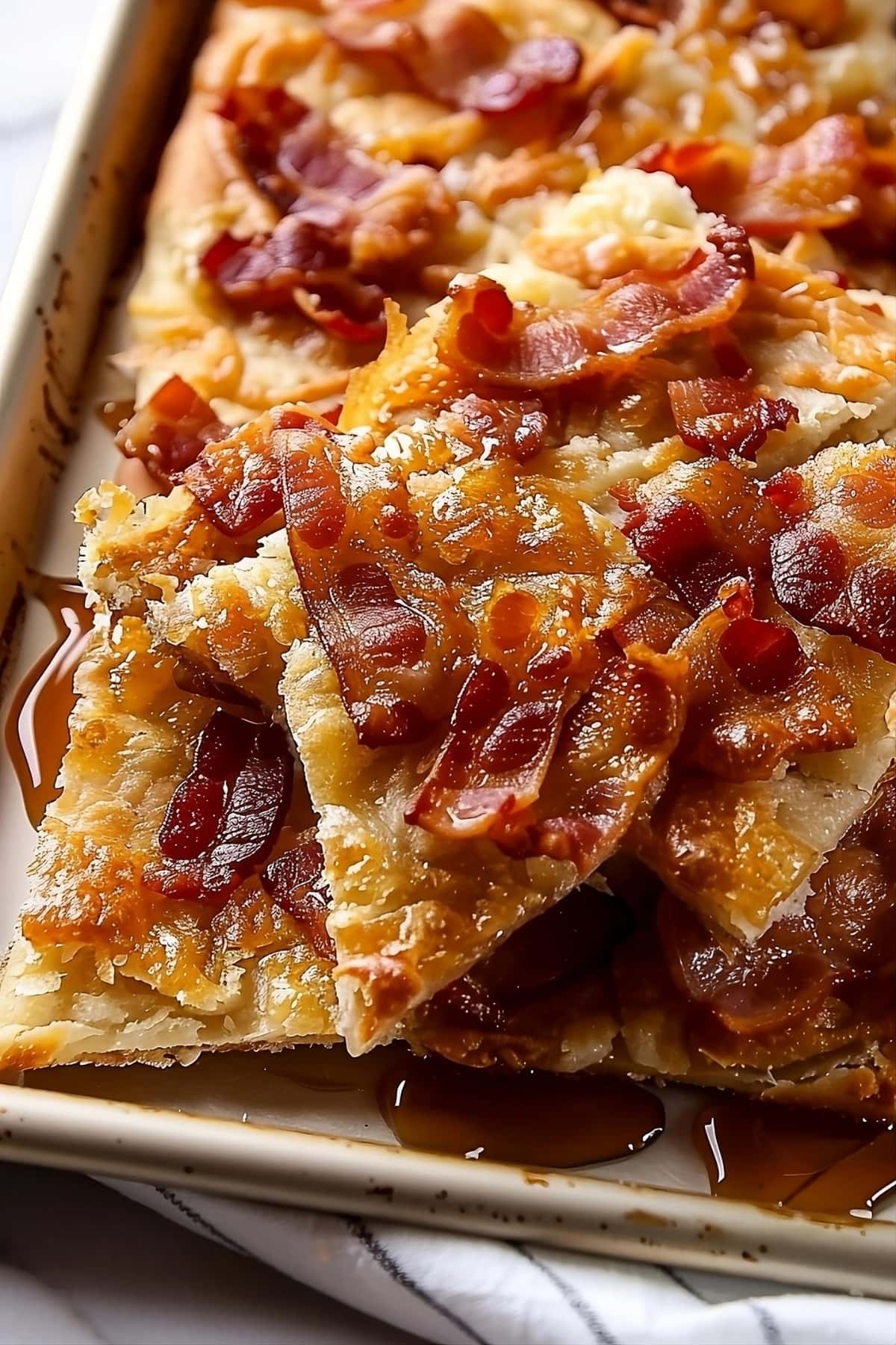 Glazing with syrup, maple bacon crack on a baking sheet.