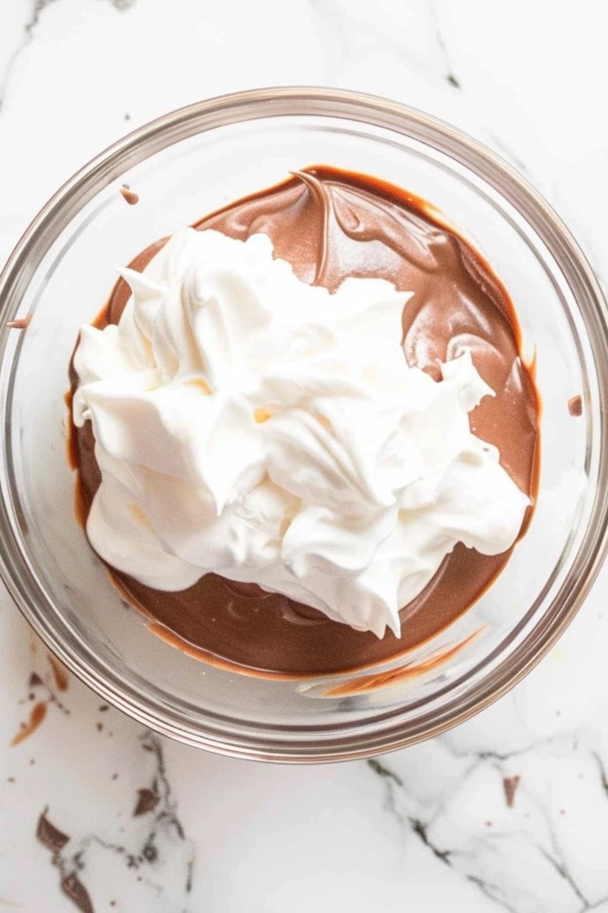 Whipped cream mixed in a bowl of melted chocolate.