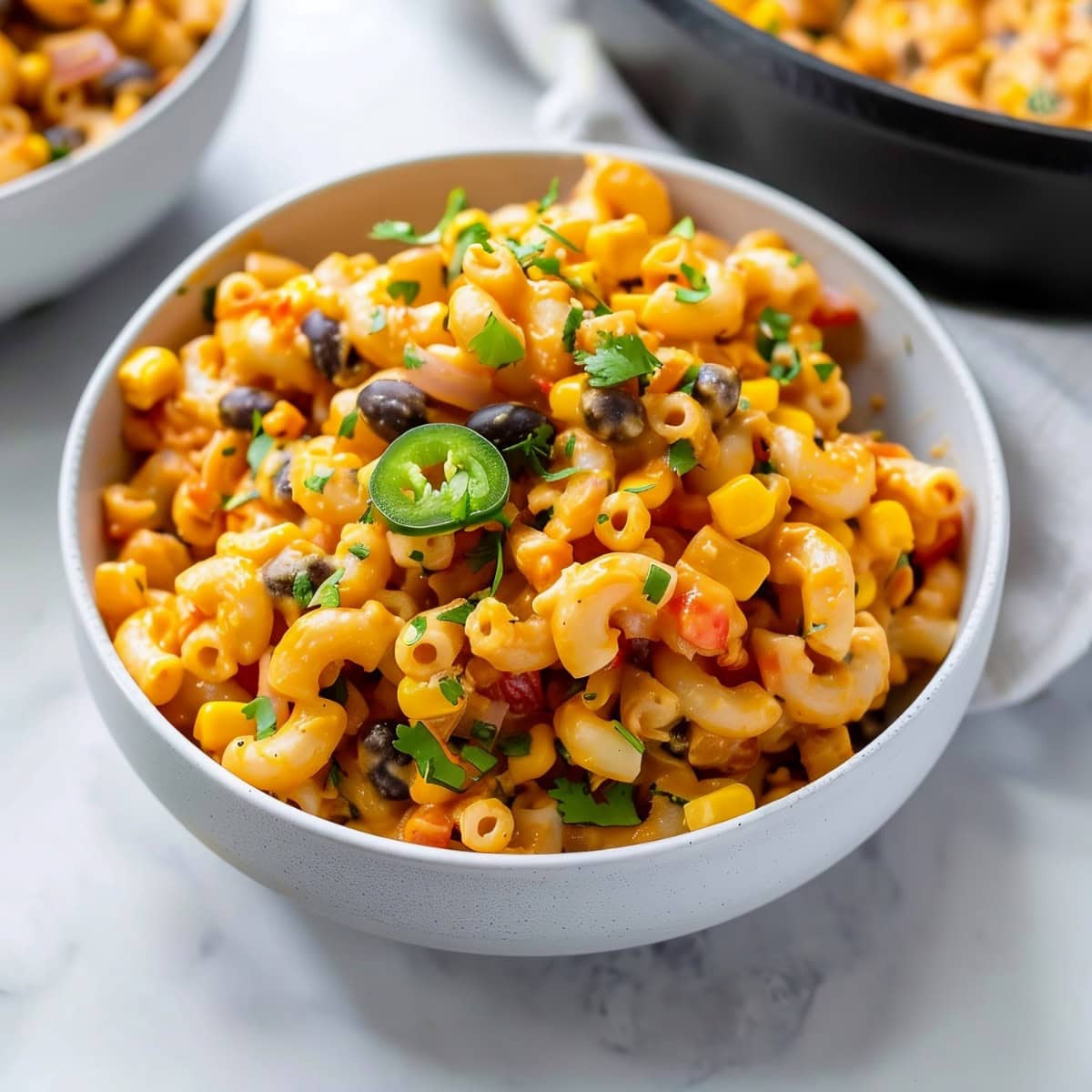 Spicy Mexican mac and cheese, featuring cheesy sauce, jalapenos, bell peppers, black beans and cilantro