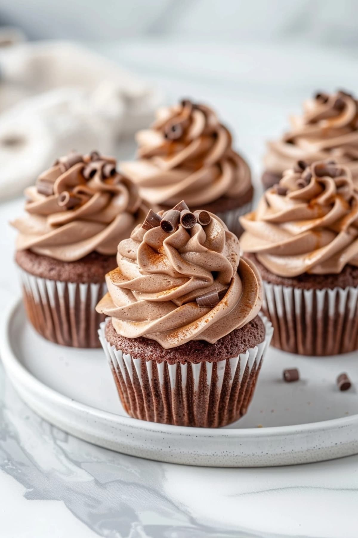 Mini cupcakes topped with chocolate whipped cream.