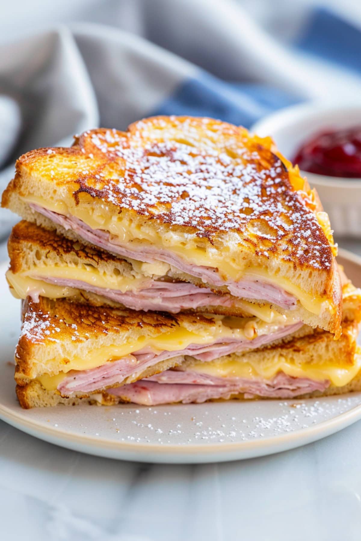 Irresistible Monte Cristo sandwich, featuring layers of savory meats and melted cheese between slices of golden-brown brioche French toast.