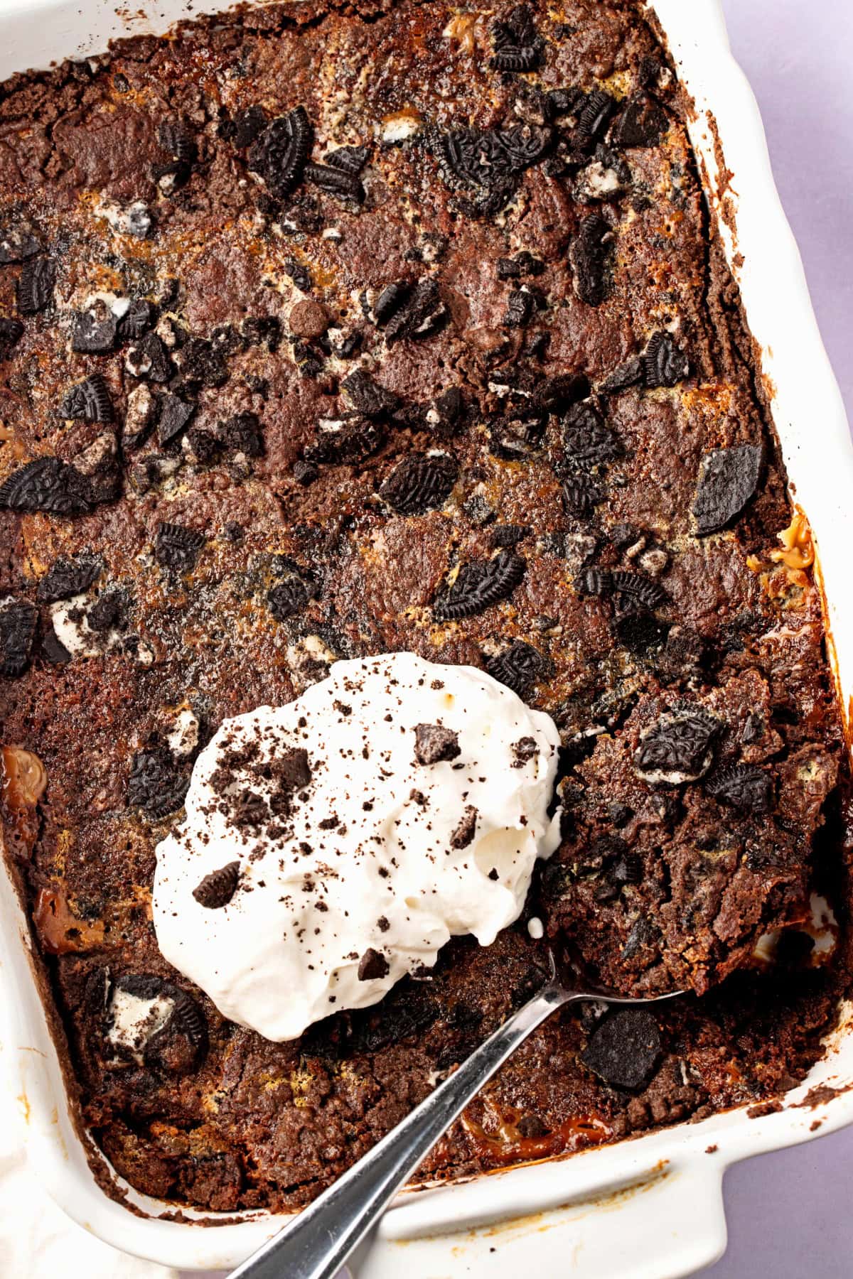 Oreo dump cake with whipped cream topping in a baking dish