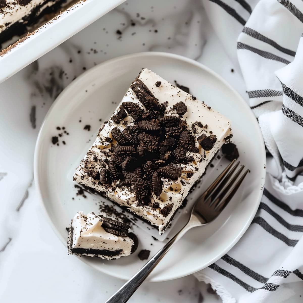 Dreamy Oreo icebox cake with extra cookies on top on a white plate, top down view