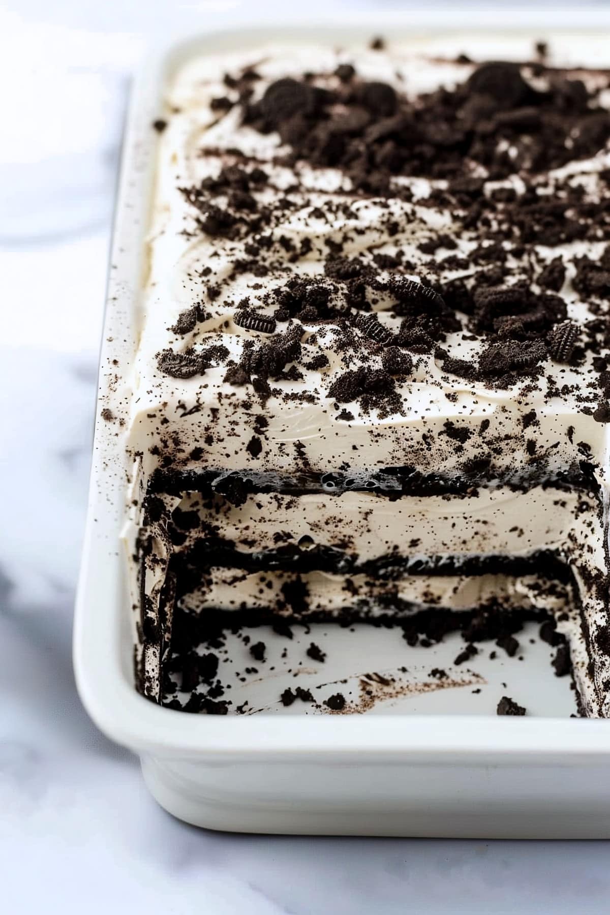 Three layered, no-bake Oreo icebox cake in a 9x13 casserole dish topped with crushed cookies