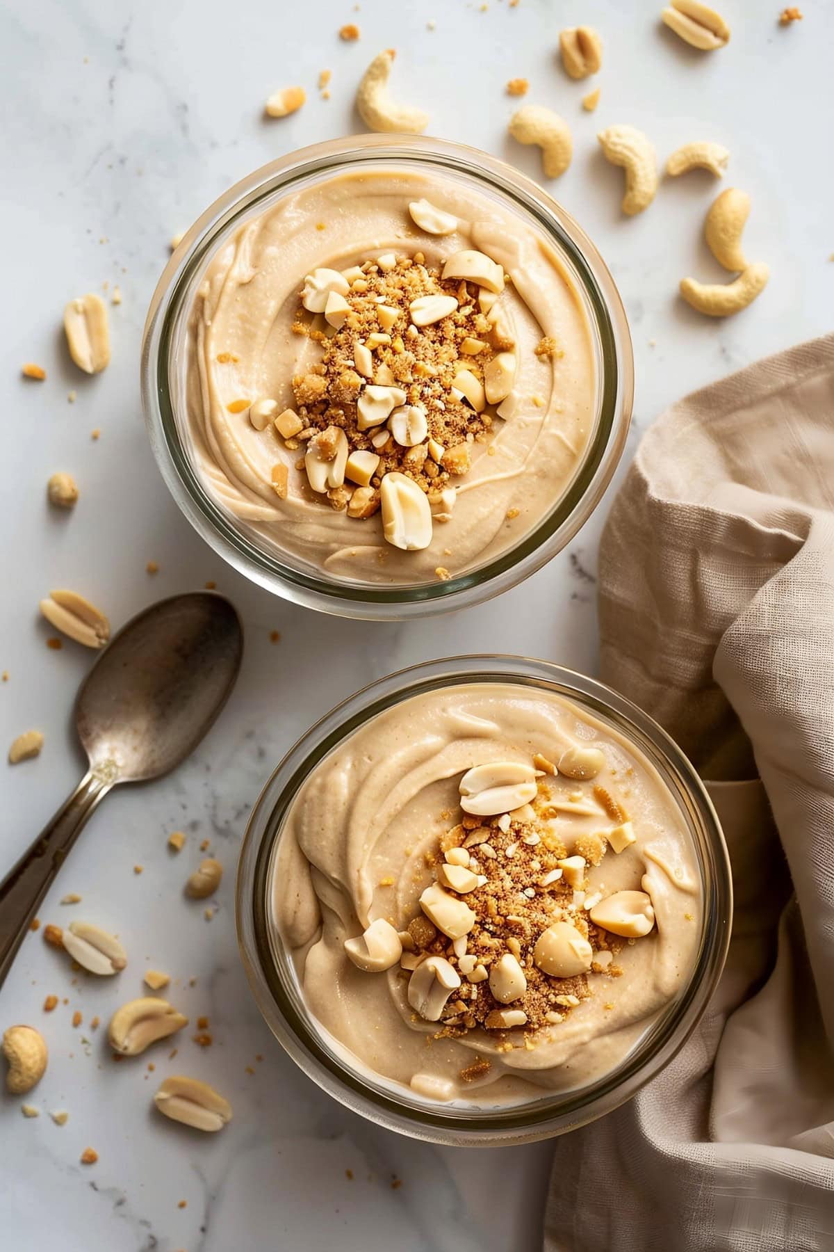 Two glasses of peanut butter mousse with crunchy crushed nuts