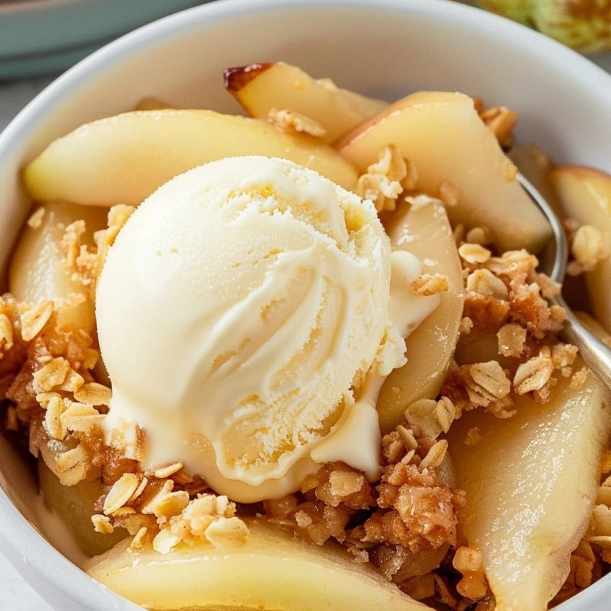 Pear crisp with vanilla ice cream closeup served on a white bowl.