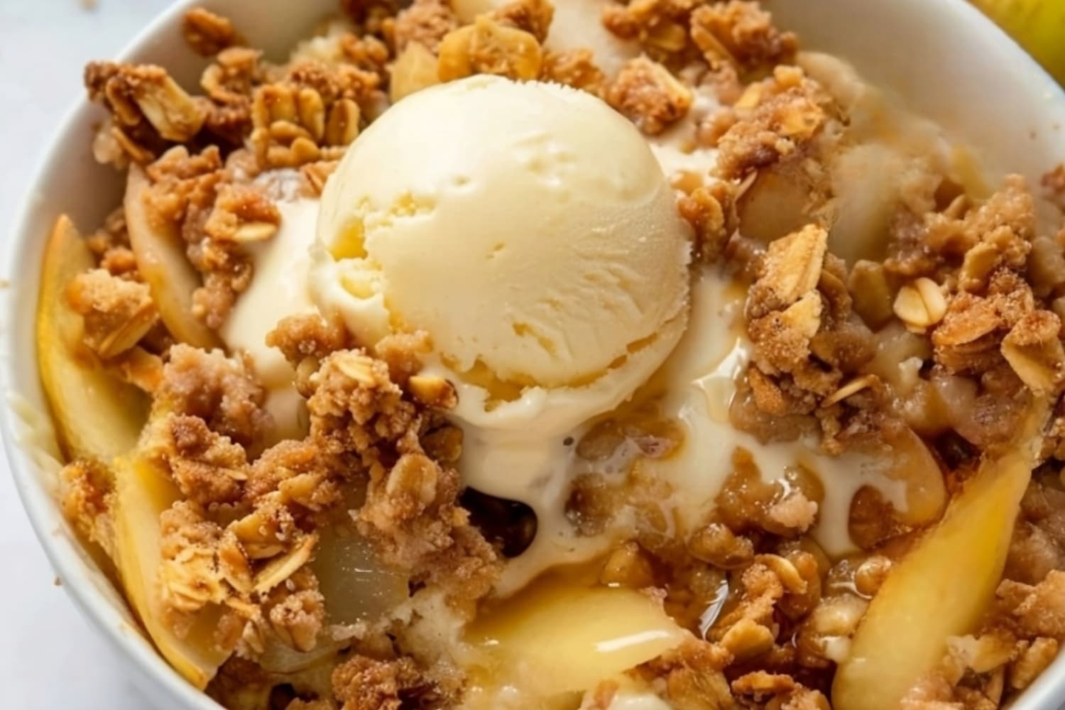Bowl of pear crisp with ice cream on top.