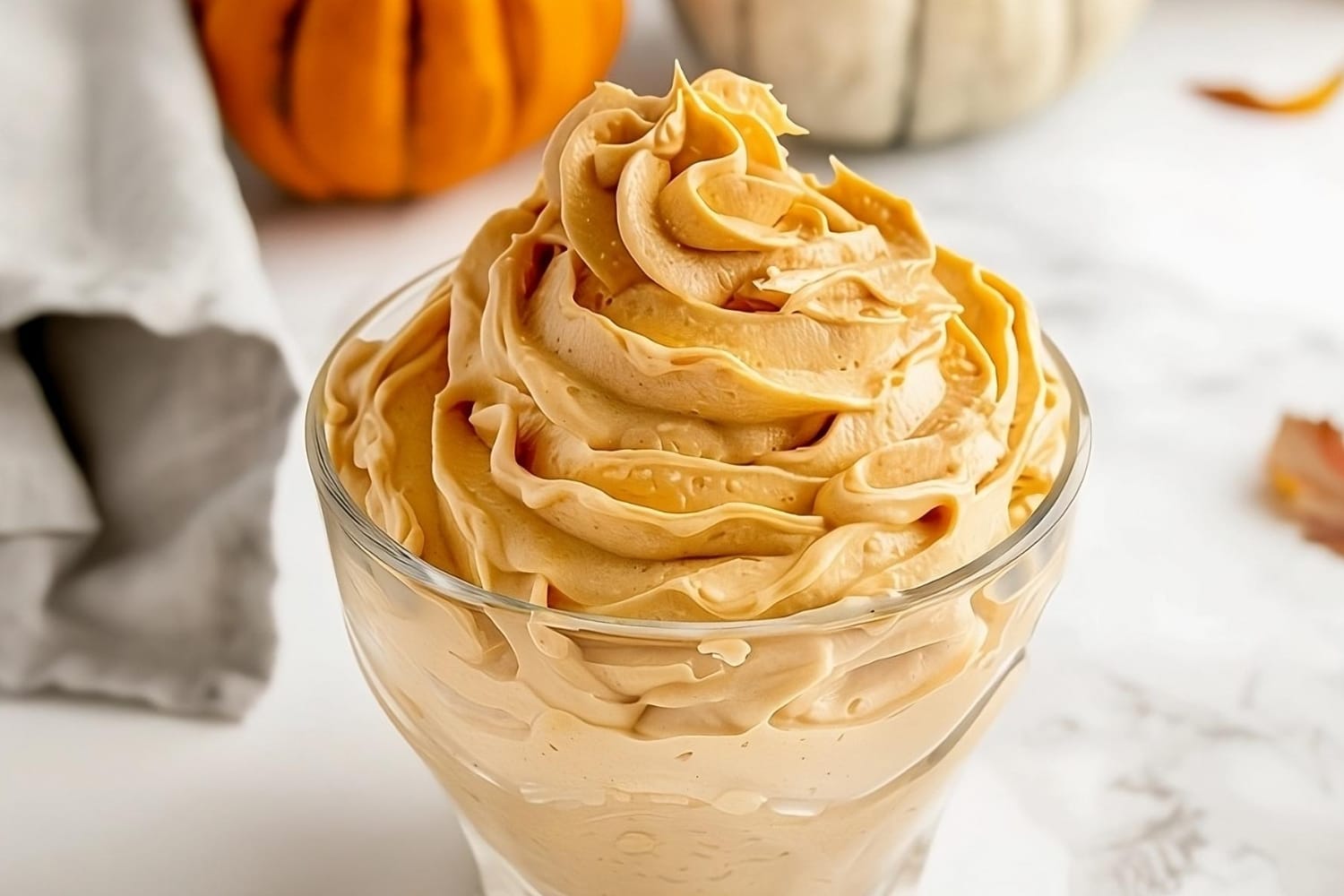 Pumpkin whipped cream in a small glass bowl.