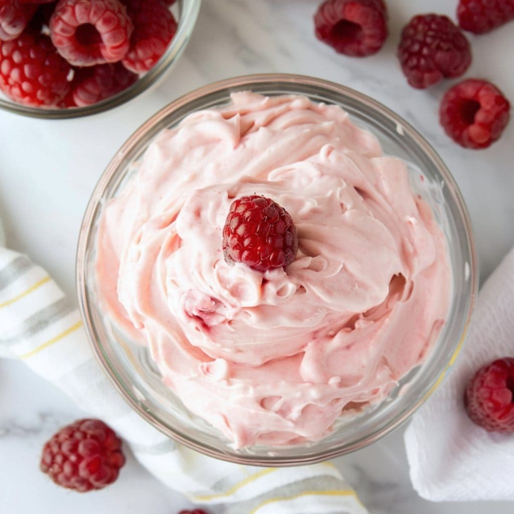 Whipped cream infused with the vibrant hue and tangy taste of ripe raspberries