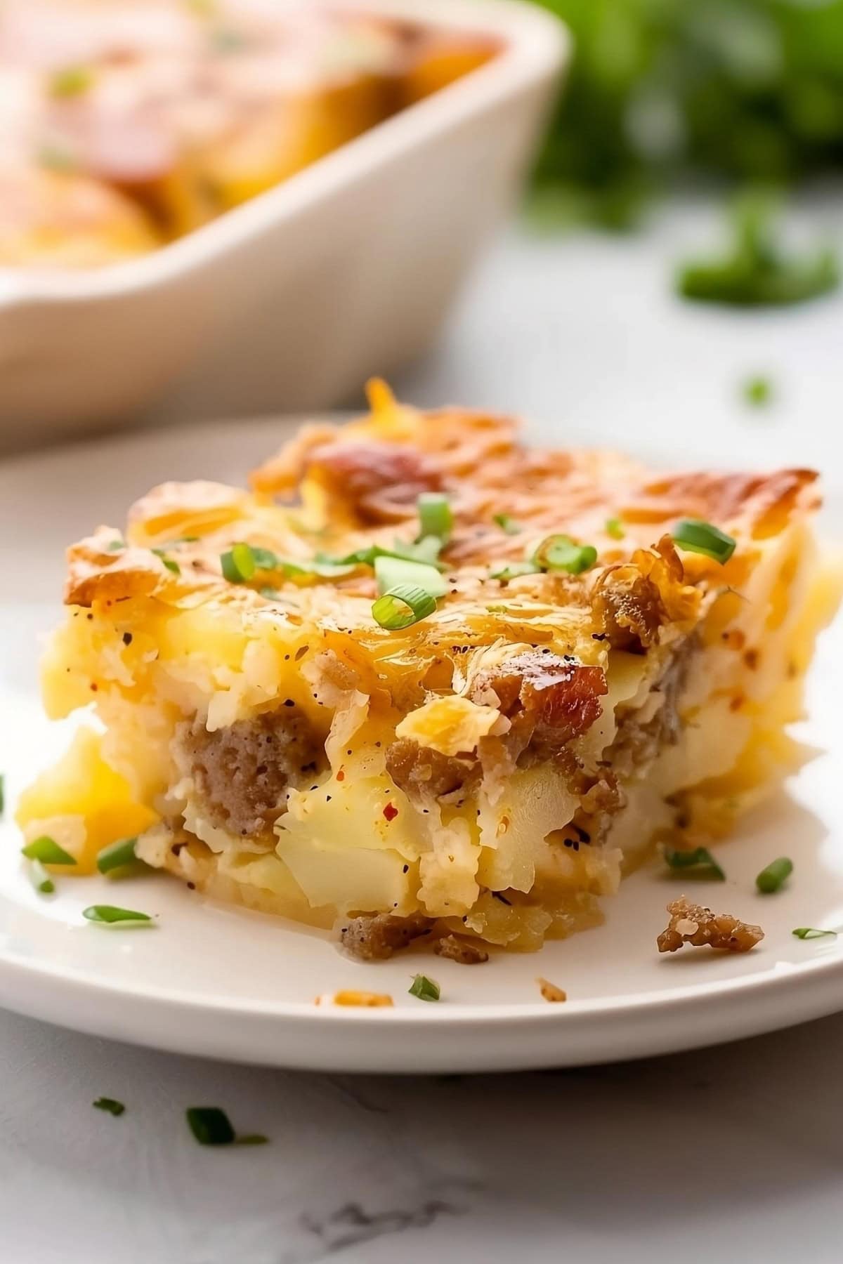 Slice of sausage hashbrown breakfast
casserole on a white plate.