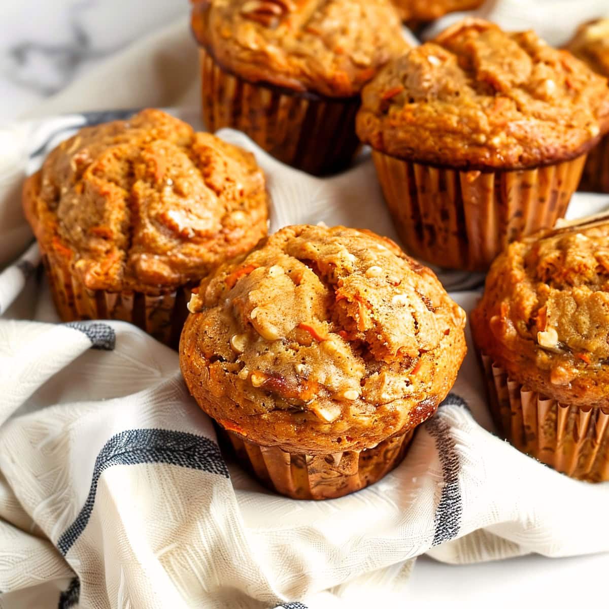 Mouthwatering carrot cake muffins, bursting with the flavors of cinnamon and crushed nuts