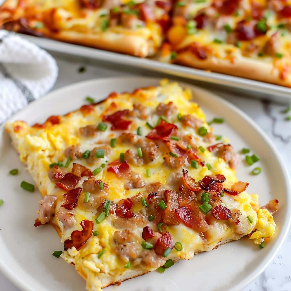 Scrumptious breakfast pizza featuring a blend of cheeses, chopped onions, bacon and sausage