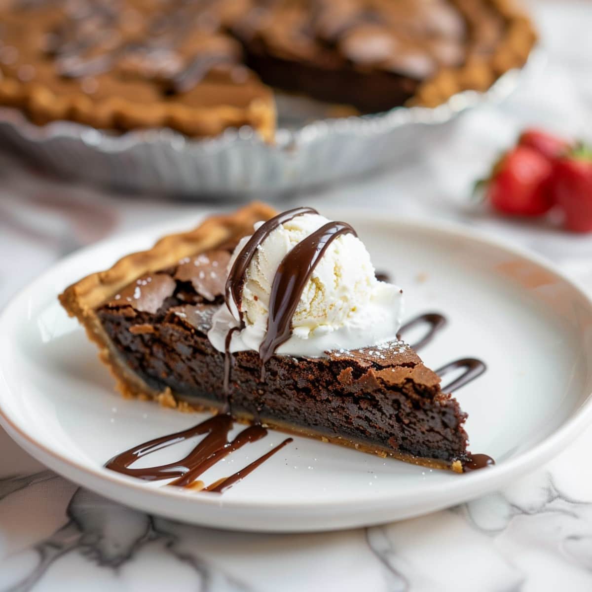 A slice of brownie pie, garnished with swirls of chocolate sauce and topped with a scoop of ice cream
