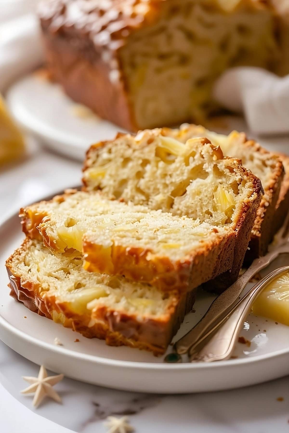 Sliced pineapple quick bread on a plate.