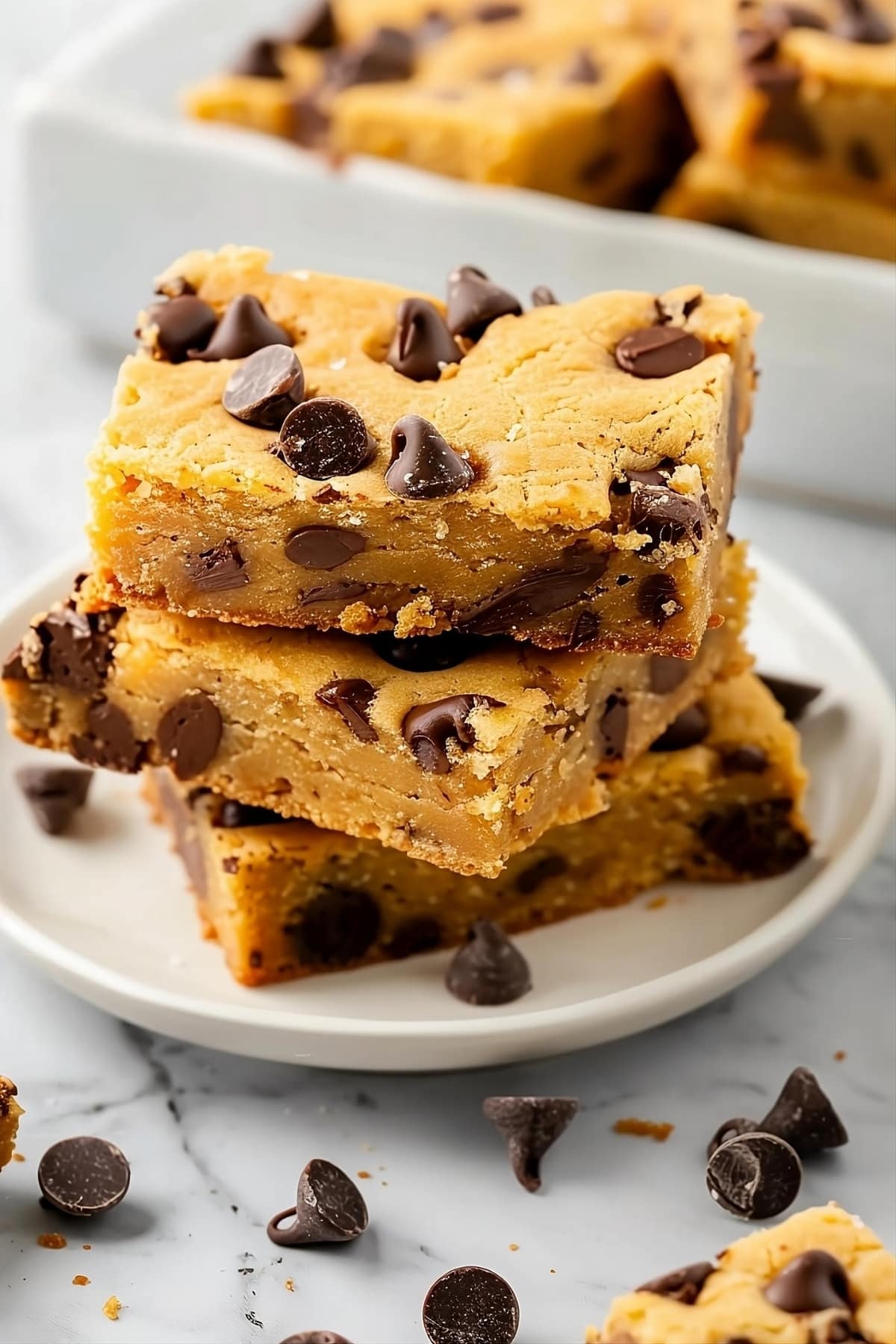 Cake mix cookie bars with chocolate chips on a white plate.
