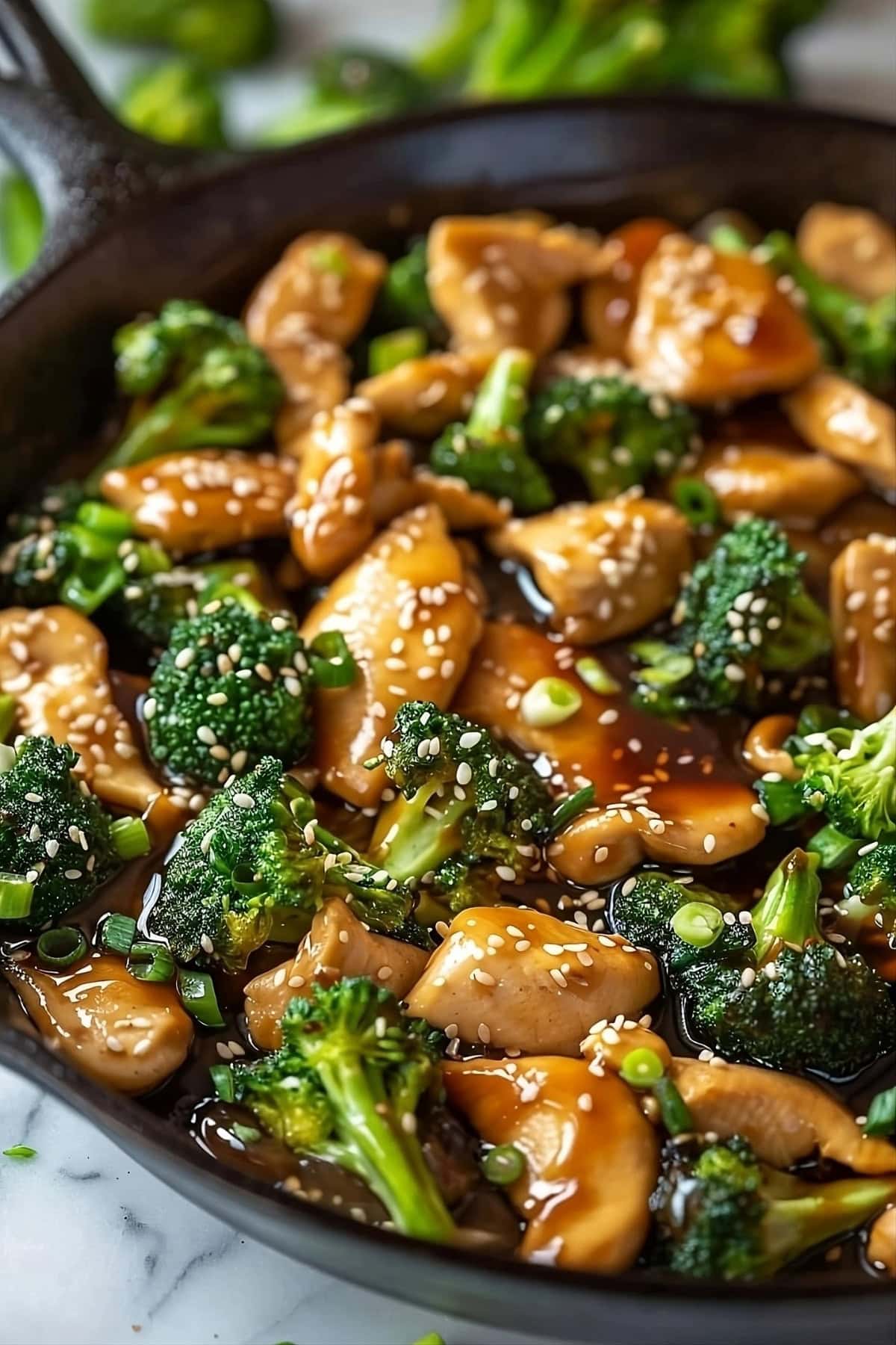 Chicken and broccoli in a cast iron pan with sauce   made with chicken broth, oyster sauce, soy sauce, rice wine vinegar, brown sugar, sesame oil, and cornstarch.
