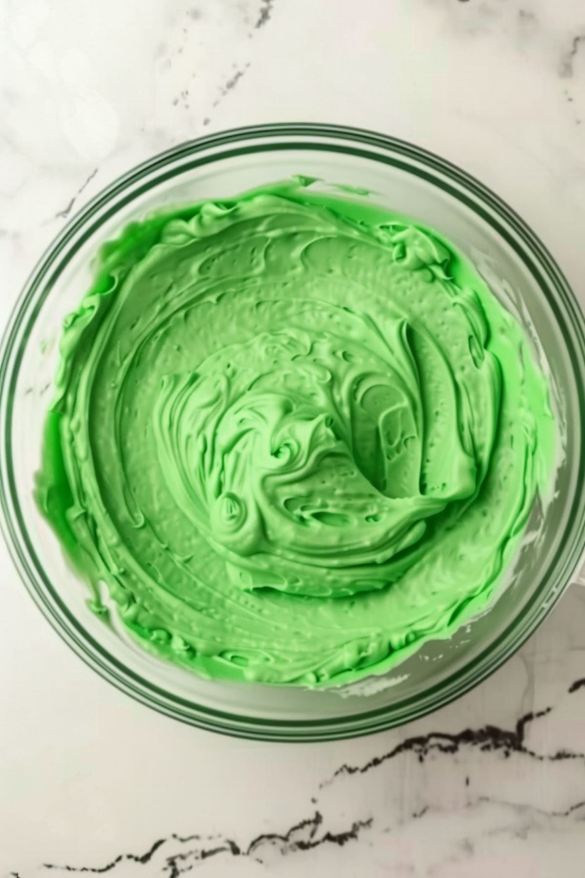 A glass bowl of green, mint pudding for Shamrock shake pie, overhead view