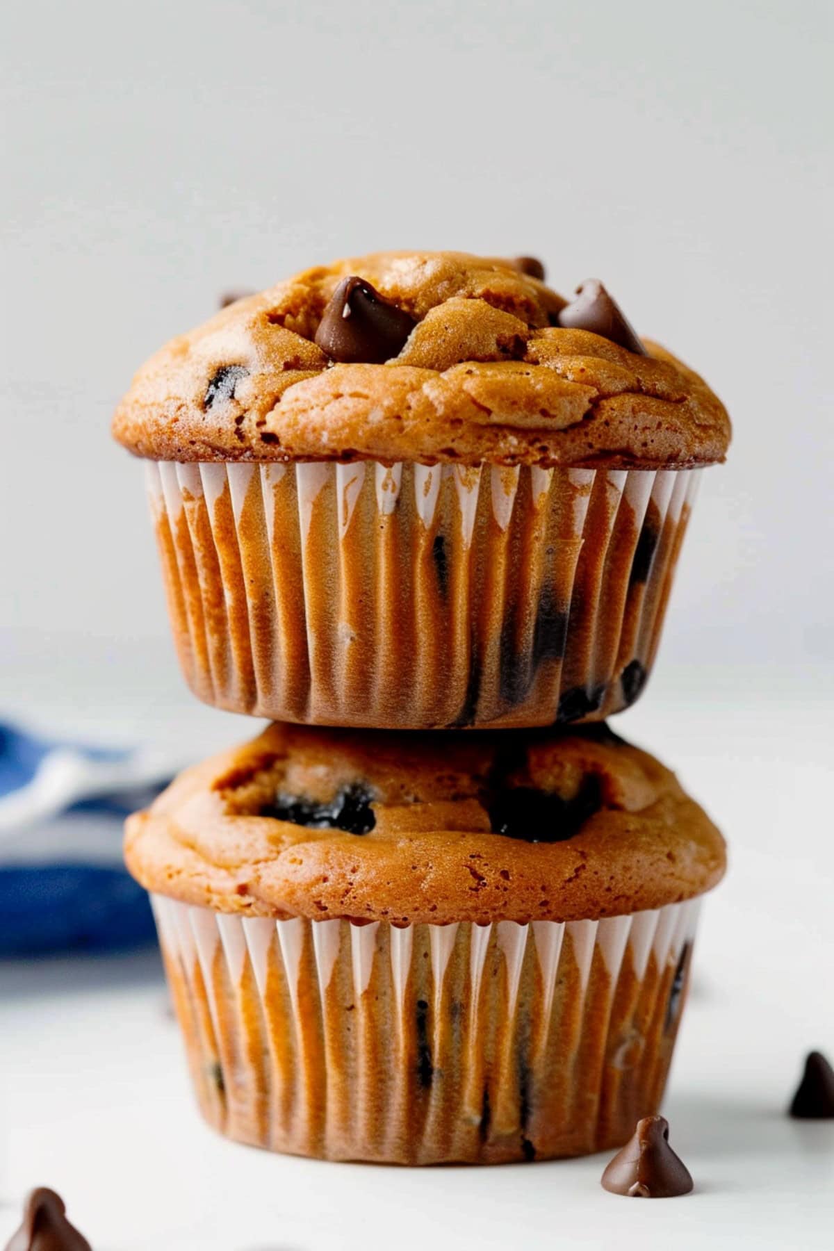 Stack of irresistible peanut butter muffins with chocolate chips on a white marble countertop
