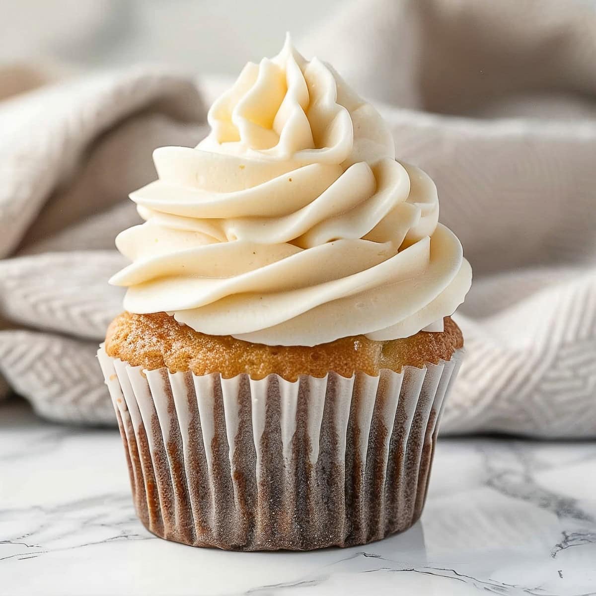 A fluffy vanilla cupcake topped with peanut butter frosting