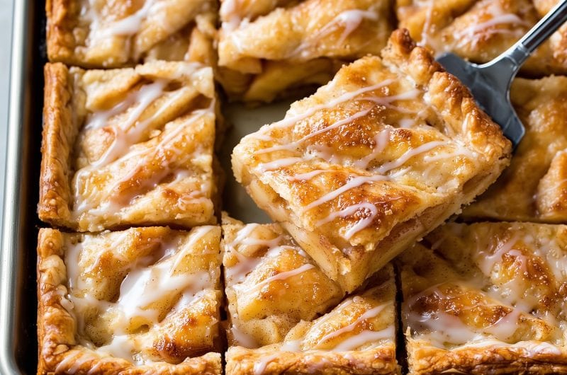 Apple slab pie, one slice is being lifted by a spatula.