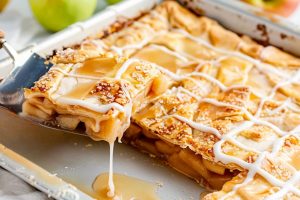 Apple slab pie slice lifted by spatula.