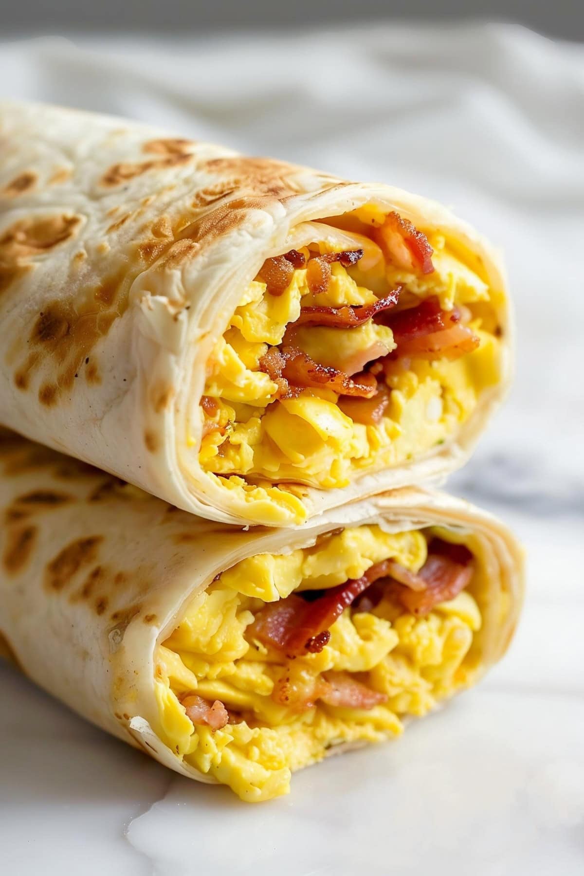 A breakfast wrap overflowing with bacon, egg and cheese.