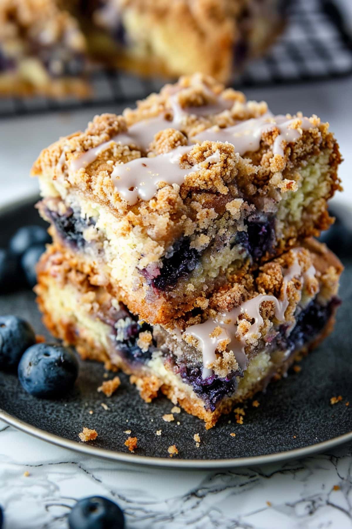 Homemade blueberry coffee cake topped with streusel crumble and vanilla glaze.