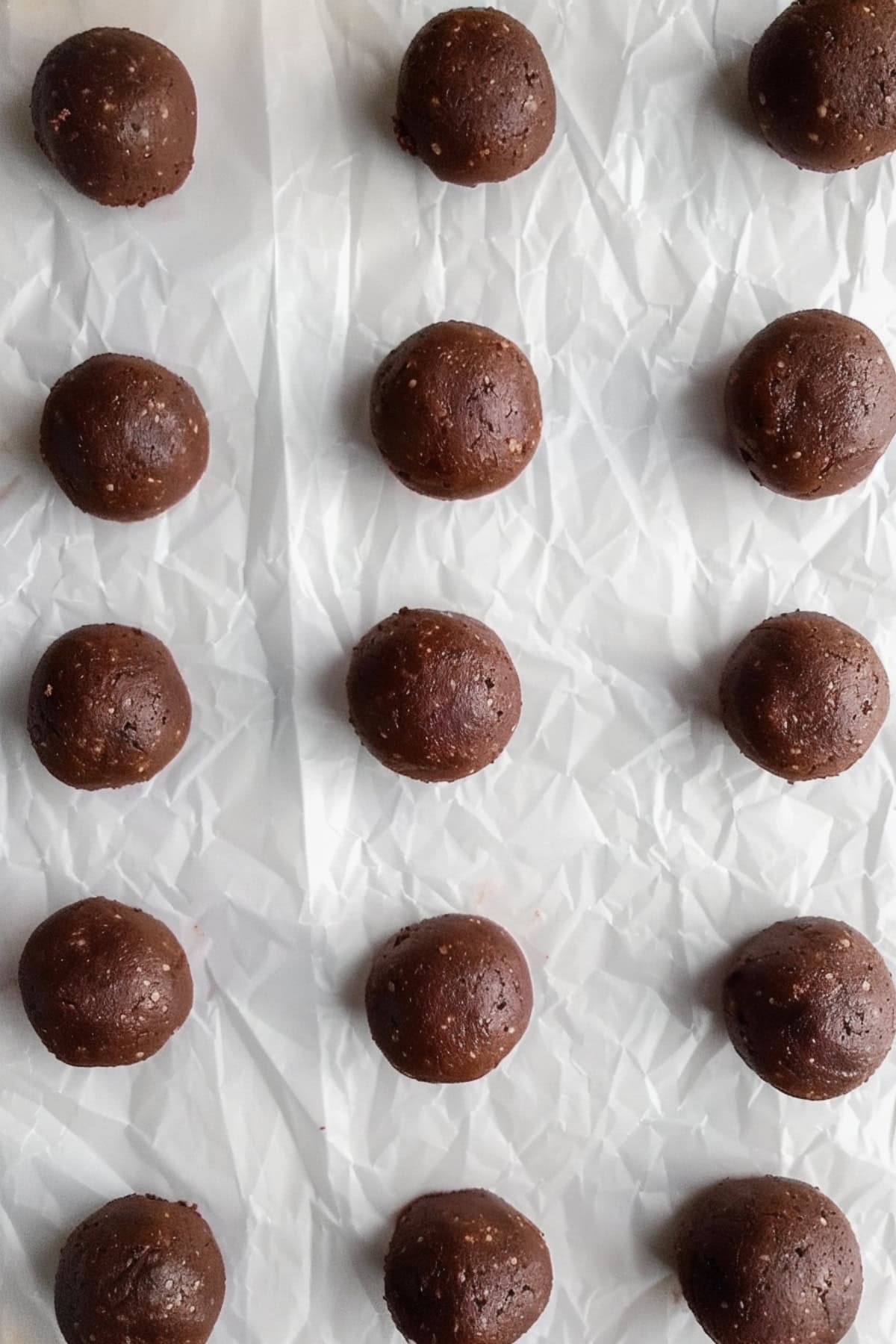 Brownie truffles sitting on a white parchment paper, overhead view