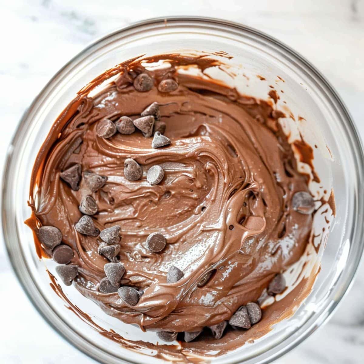 Brownie batter dip with chocolate chips mixed in a glass bowl.