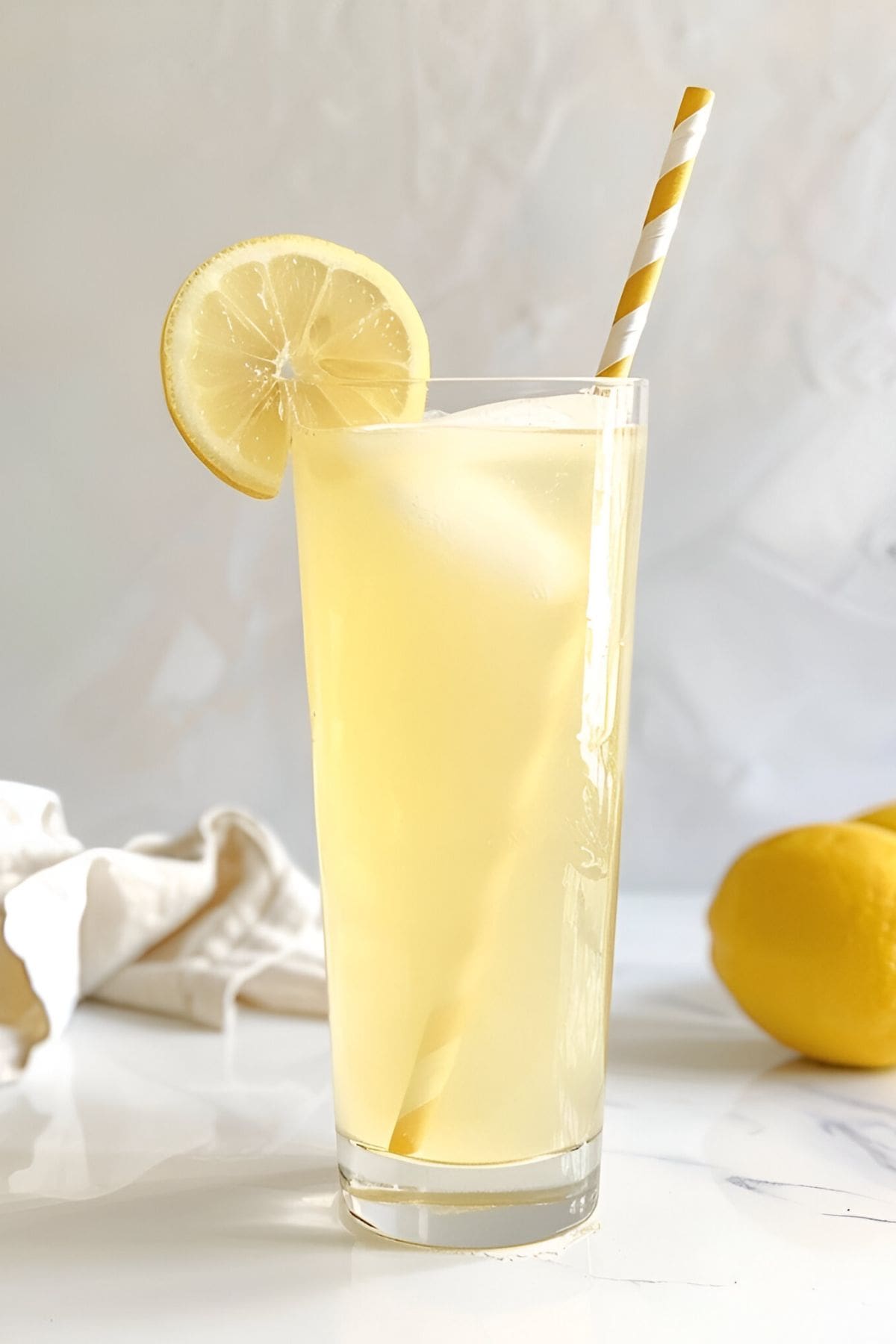 Chick-Fil-A Lemonade in a Tall Glass with Ice and a Wheel of Lemon for Garnish with a Striped Straw