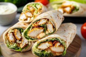 A tasty chicken Caesar wrap made with chicken, fresh lettuce and dressing, all rolled into a soft tortilla