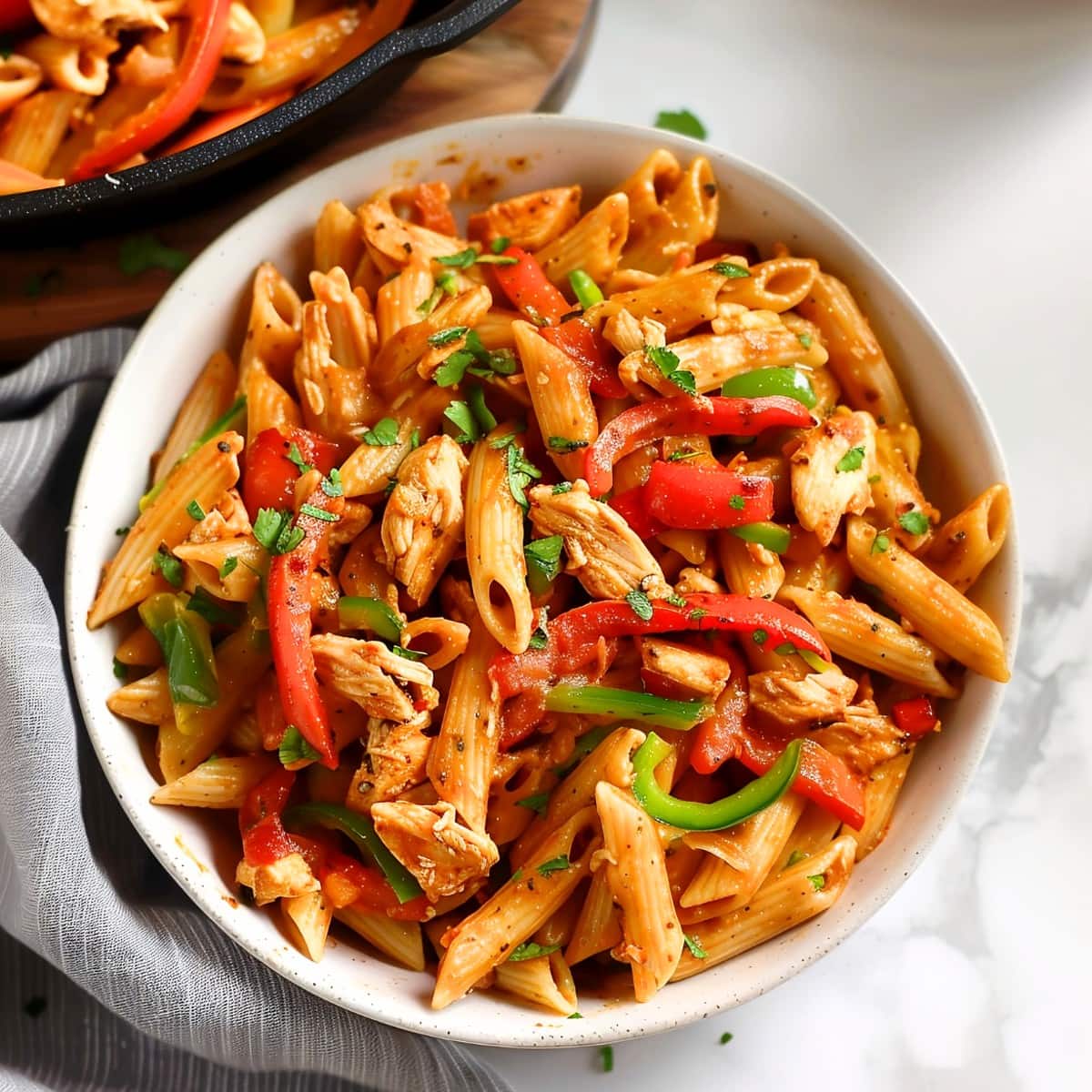 Chicken fajita penne pasta with colorful bell peppers and cilantro in a bowl