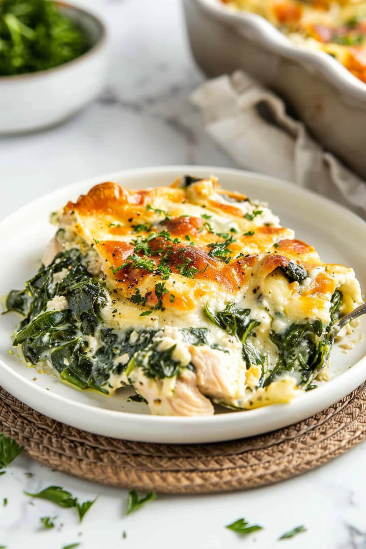 Chicken and spinach casserole in a white plate.