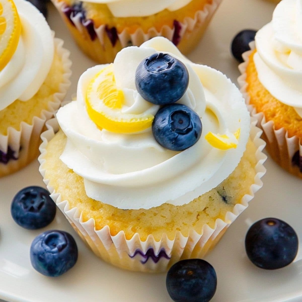 Lemon blueberry cupcakes with blueberries and lemon slice.