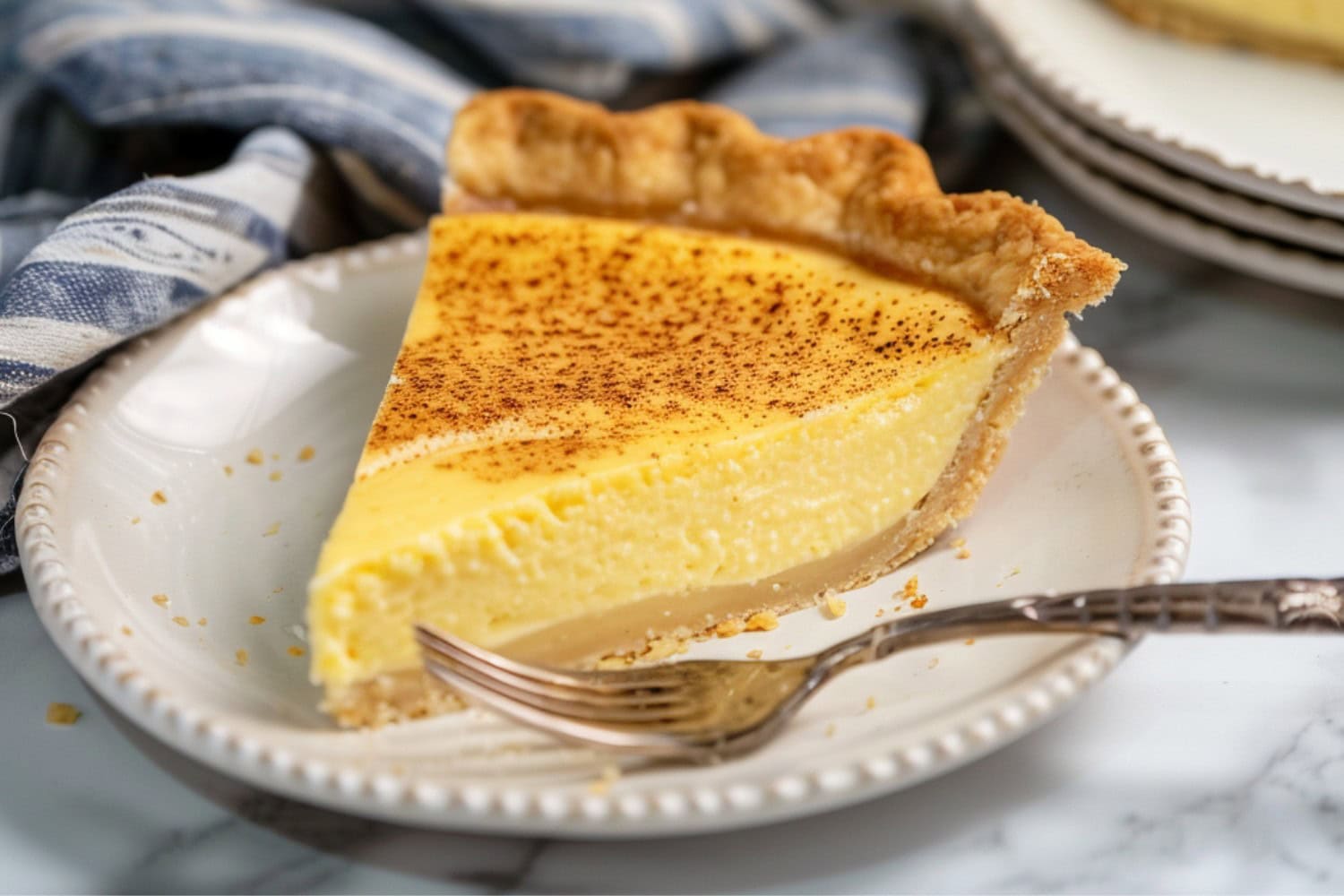 A delightful slice of custard pie topped with ground nutmeg
