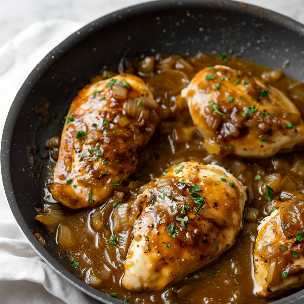 Savory and flavorful French onion chicken in a black skillet