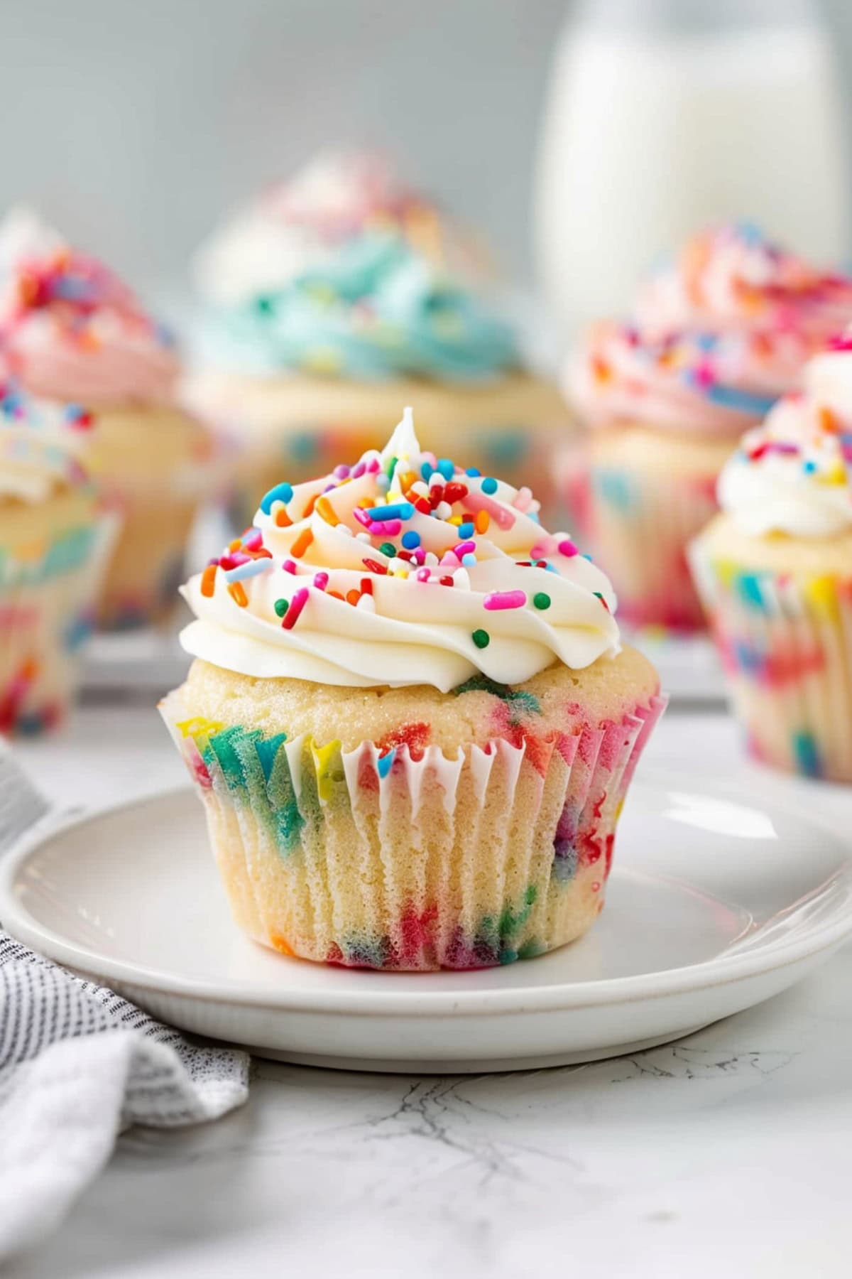 Colorful funfetti cupcakes, topped with creamy buttercream frosting and rainbow sprinkles.