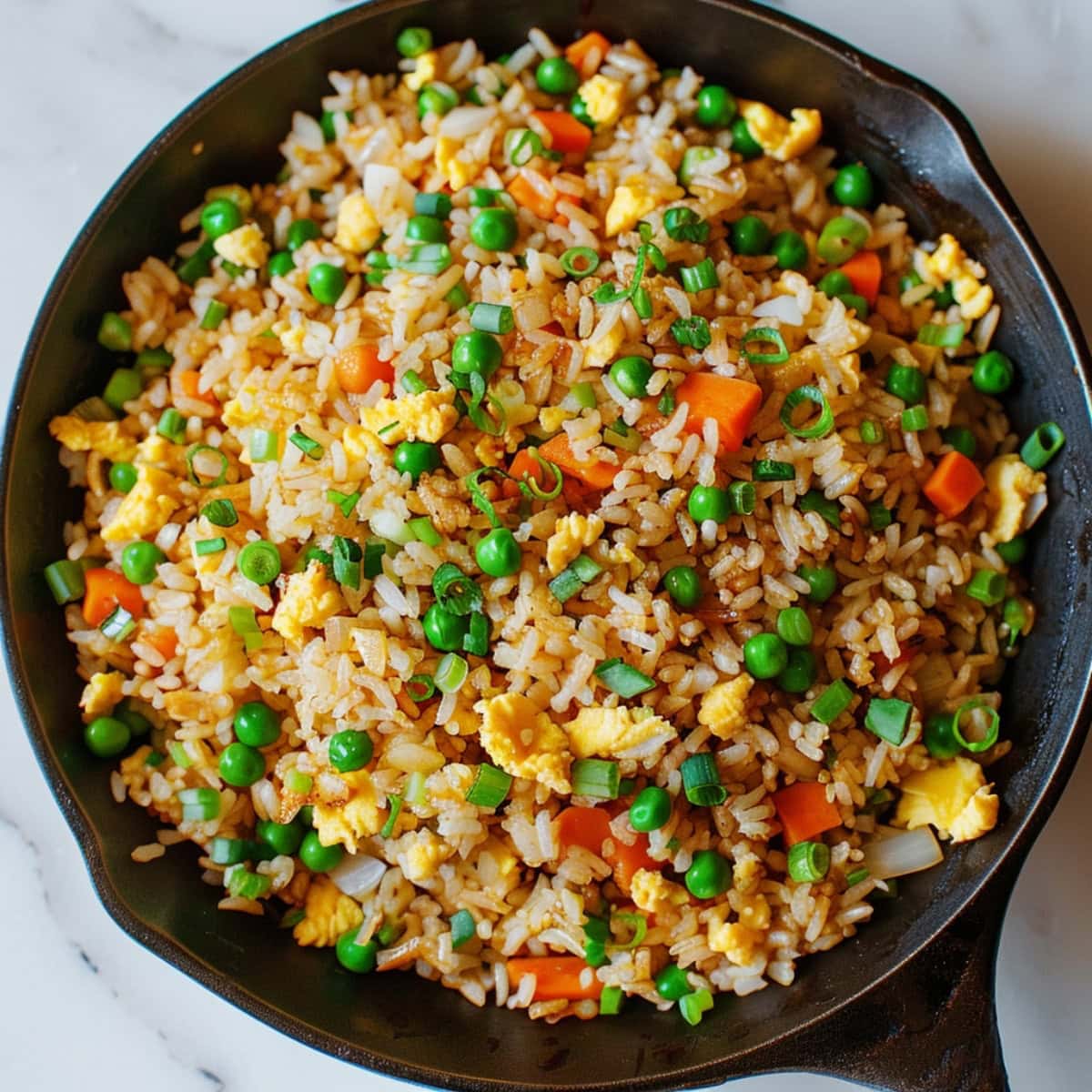 Savory hibachi fried rice in a skillet, featuring tender vegetables and scrambled eggs