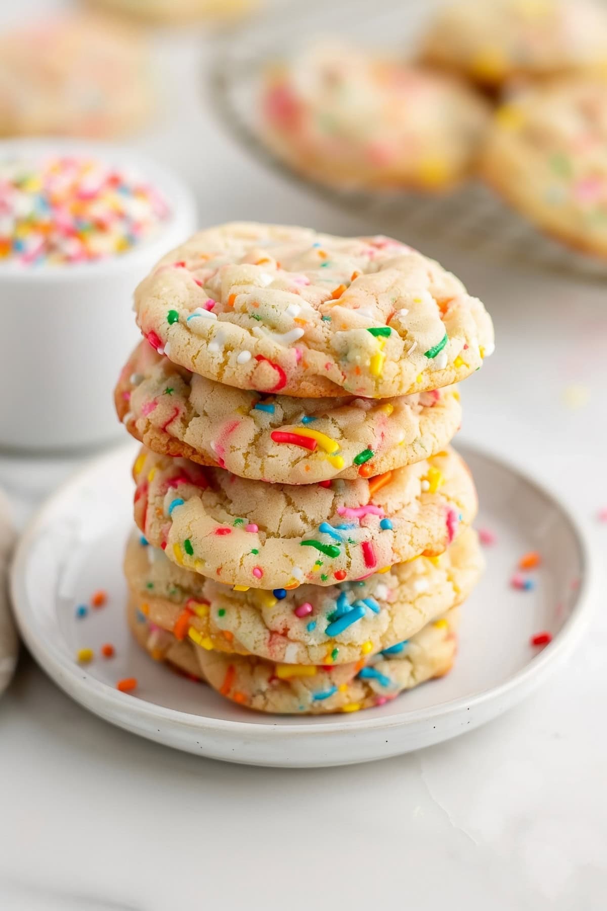 A plate of colorful funfetti cake mix cookies with rainbow sprinkles.