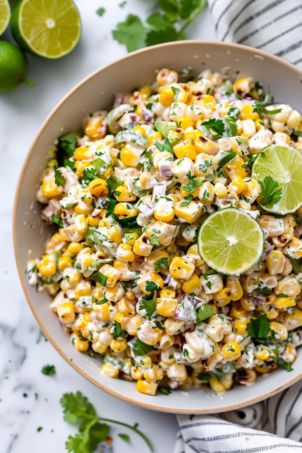Overhead view of Mexican street corn salad with cilantro, onions, and garnished with lime.