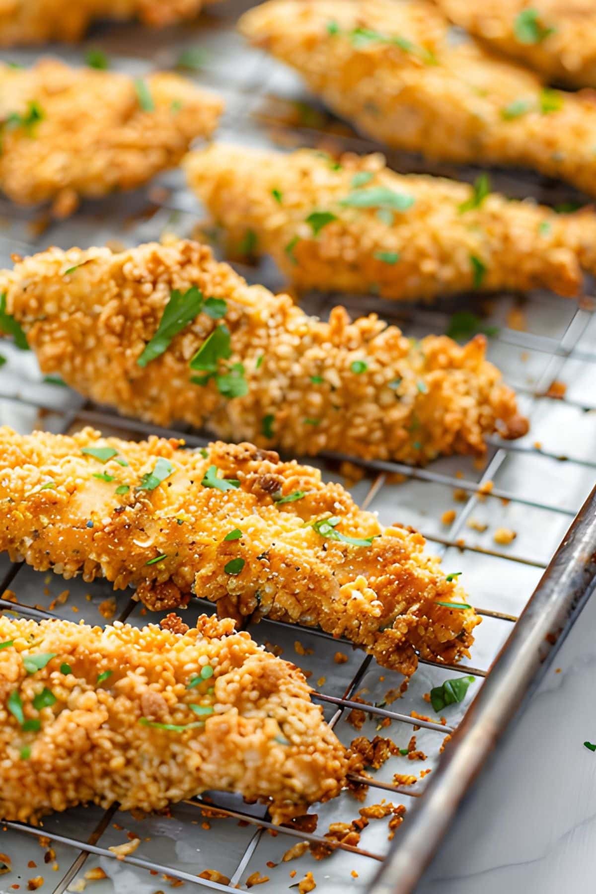 Close Up Crispy Baked Chicken Tenders on a Wire Rack on a Baking Tray