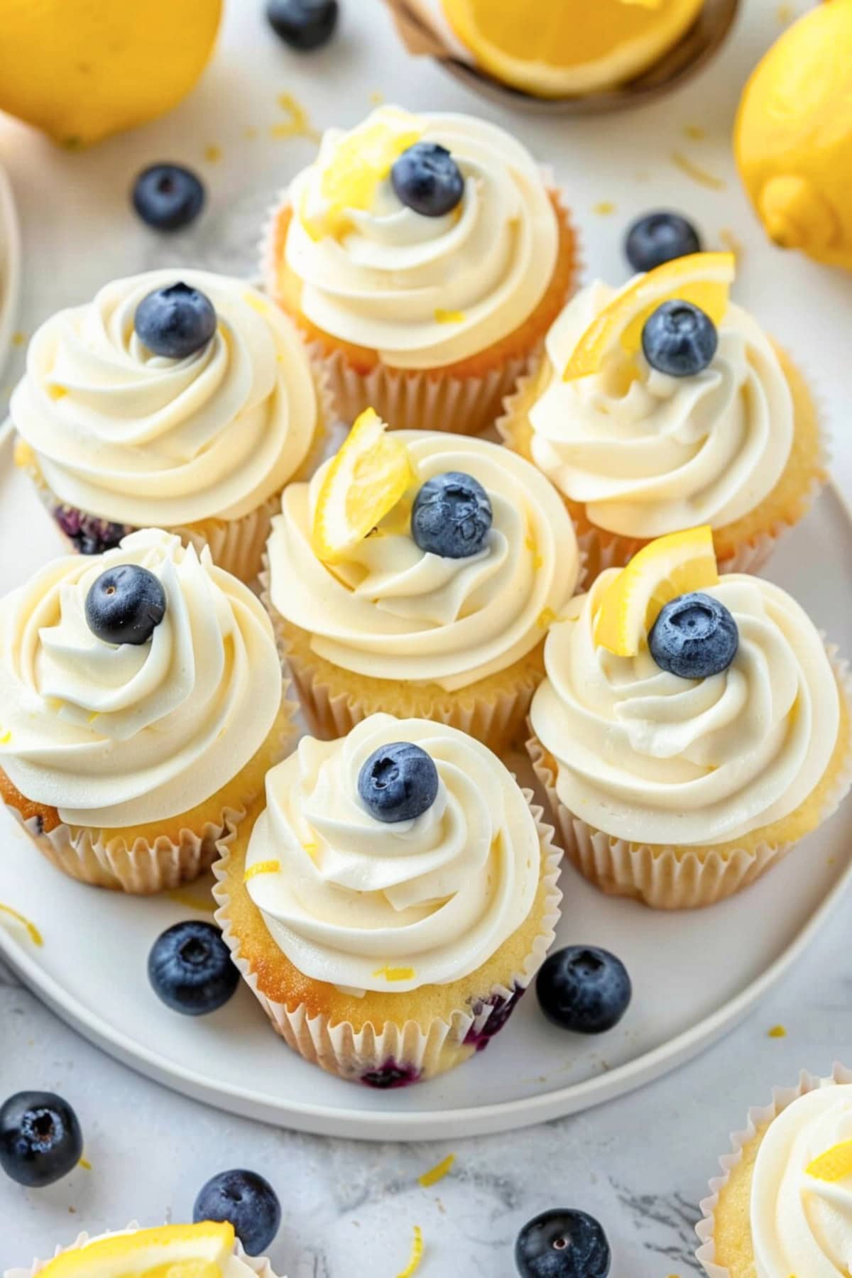 Cupcakes with lemon and blueberry topped with creamy buttercream frosting served in a plate.