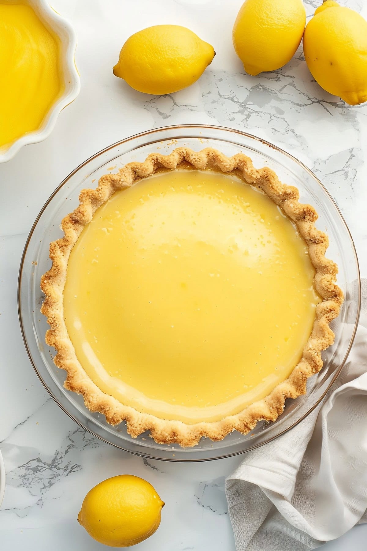 Lemon custard in a pie crust on a glass pie dish
