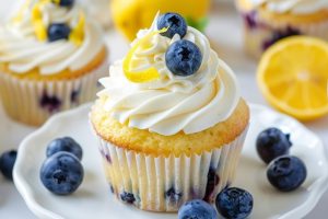 Lemon blueberry cupcake in a plate topped with buttercream frosting.