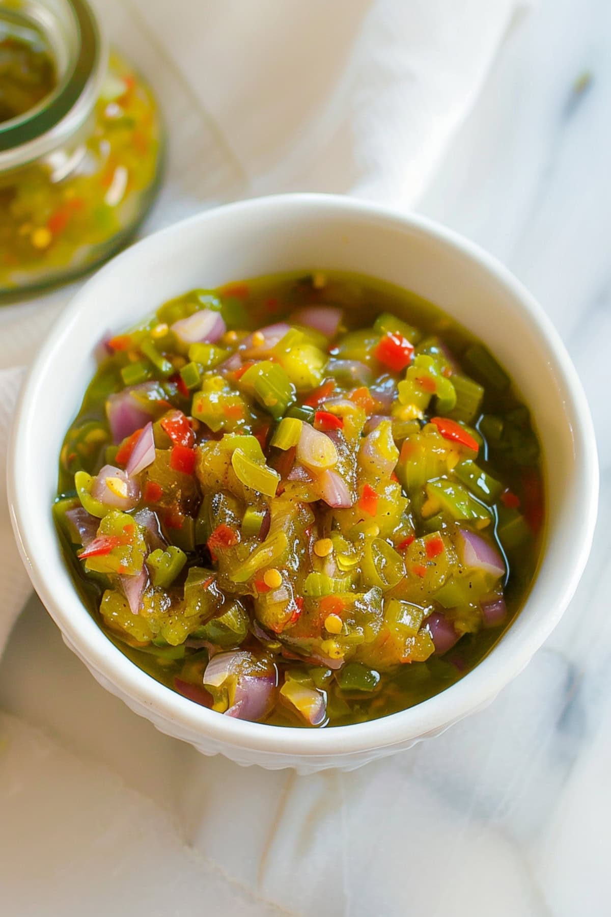 Pepperoncini relish in a white bowl with bell peppers and onions