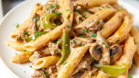 Philly Cheesesteak Pasta served in plate with fork on the side.