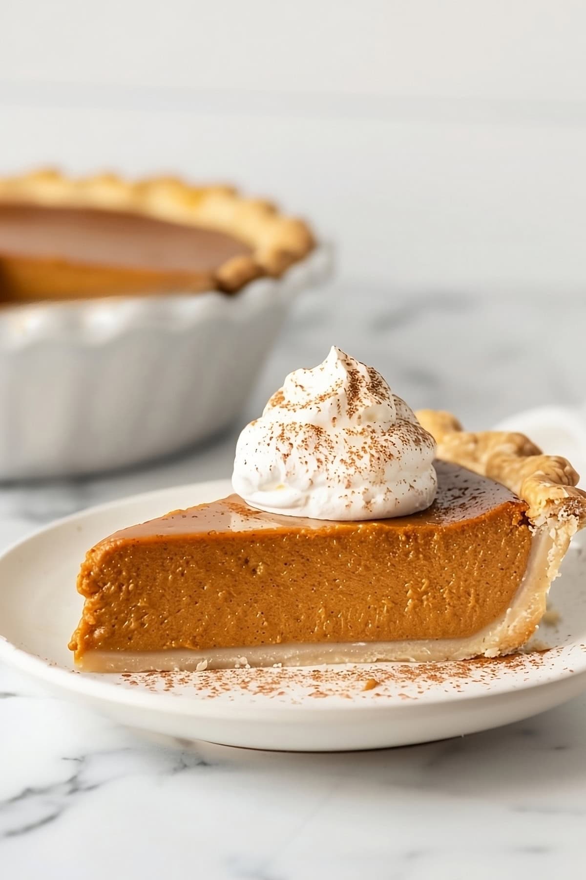 Slice of pumpkin with eggnog whipped cream on top.