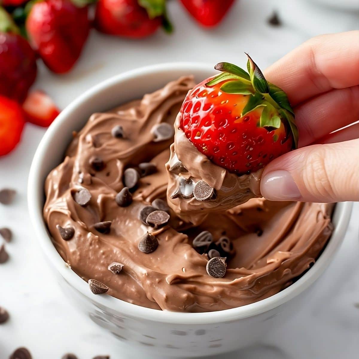 Strawberry dipped in brownie batter on a bowl. 