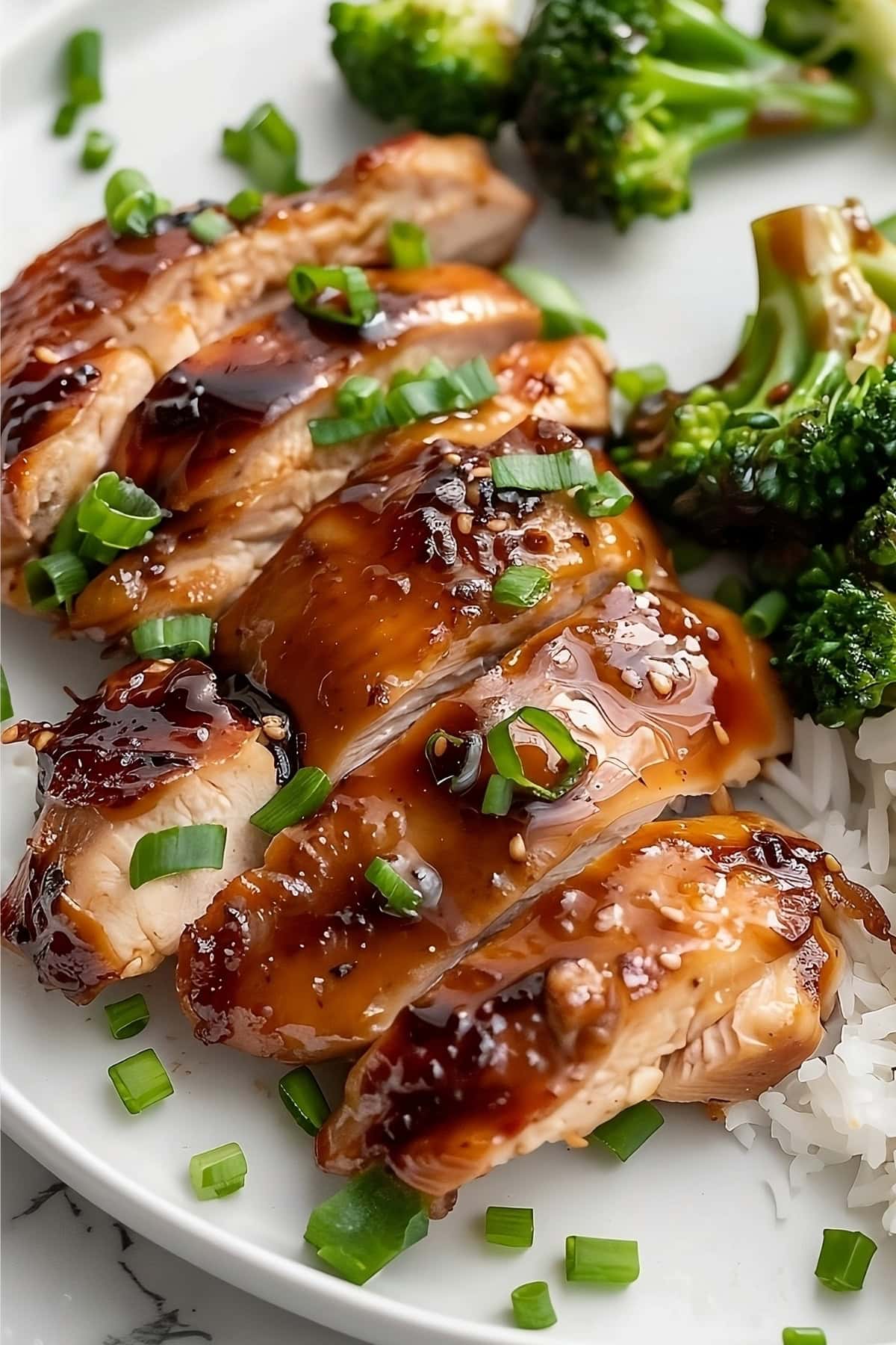 Sliced teriyaki chicken thigh served with rice and steamed broccoli.